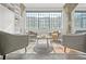 Bright living room showcasing gray chairs, large windows, white brick walls, and polished concrete floors at 434 Marietta St Nw # 401, Atlanta, GA 30313