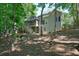 Home exterior with a back yard, a screened in porch, wooden stairs, and mature shade trees at 1328 Amberwood Dr, Woodstock, GA 30189