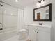 Bright, updated bathroom with white cabinets, a large mirror, modern lighting, and a tub with shower at 1328 Amberwood Dr, Woodstock, GA 30189