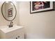 Powder room featuring a round mirror, vanity, decorative art, and stylish black faucet at 1328 Amberwood Dr, Woodstock, GA 30189