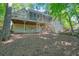 Back of home featuring screened porch, deck, stairs, and large lot with mature landscaping at 1328 Amberwood Dr, Woodstock, GA 30189