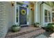 Inviting front entrance with a decorative wreath, brick steps, and elegant potted plants at 1328 Amberwood Dr, Woodstock, GA 30189