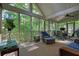 Inviting screened porch with wicker seating, ceiling fan, and views of the surrounding trees at 1328 Amberwood Dr, Woodstock, GA 30189
