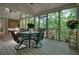 Charming screened porch with a glass table, chairs, and lush green views, creating a serene retreat at 1328 Amberwood Dr, Woodstock, GA 30189