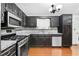 Kitchen featuring wood floors, stainless steel appliances, granite countertops and black cabinets at 1822 Oriole Trl, Lithia Springs, GA 30122