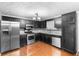 Kitchen featuring wood floors, stainless steel appliances, granite countertops and black cabinets at 1822 Oriole Trl, Lithia Springs, GA 30122