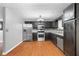 Kitchen featuring wood floors, stainless steel appliances, granite countertops and black cabinets at 1822 Oriole Trl, Lithia Springs, GA 30122