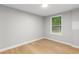Bright bedroom featuring light hardwood floors and a window with a view of the lush greenery outside at 4212 Bryan Se Dr, Acworth, GA 30102