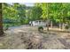 Exterior view showcasing lush landscaping, including a covered front porch and a tree-lined backdrop, exuding curb appeal at 4212 Bryan Se Dr, Acworth, GA 30102