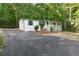 Charming home with a covered front porch, dark shutters, and an asphalt driveway surrounded by lush trees at 4212 Bryan Se Dr, Acworth, GA 30102