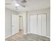 Bedroom features modern light fixture, three closets, and wood-look floors at 6429 Woodstone Way, Morrow, GA 30260