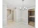 Open concept dining area with tile floors features a modern chandelier and an entrance into the kitchen at 6429 Woodstone Way, Morrow, GA 30260