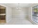 This dining room features neutral colored walls, tile flooring, modern lighting, and natural light from the window at 6429 Woodstone Way, Morrow, GA 30260