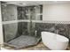 A bathroom featuring a glass walk-in shower, freestanding tub, and stylish geometric tile accents at 664 Florence Nw Pl, Atlanta, GA 30318