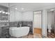 Modern bathroom showcasing a soaking tub and a glass-enclosed shower with gray tiling at 664 Florence Nw Pl, Atlanta, GA 30318
