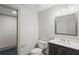 Clean half bathroom featuring dark wooden vanity, framed mirror, and light colored walls at 664 Florence Nw Pl, Atlanta, GA 30318