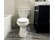 A bathroom includes a toilet, vanity with a marble countertop, and sleek neutral design elements at 664 Florence Nw Pl, Atlanta, GA 30318