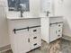 Dual vanities with white shaker-style cabinets, drawers, and striking black hardware for a contrasting touch at 664 Florence Nw Pl, Atlanta, GA 30318
