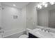 A bright bathroom featuring a tub and shower combination, and sleek white tile at 664 Florence Nw Pl, Atlanta, GA 30318