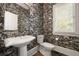 Stylish powder room with designer wallpaper, pedestal sink, and a decorative mirror at 1003 North Ne Ave, Atlanta, GA 30306