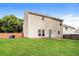 Expansive backyard with a well-maintained lawn, fence, and view of the two-story home at 11576 Kades Trl, Hampton, GA 30228