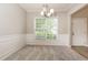 Neutral dining room with large windows, carpet, and white wainscoting at 11576 Kades Trl, Hampton, GA 30228