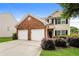 Two-story home with brick and siding, a two-car garage, and manicured landscaping at 11576 Kades Trl, Hampton, GA 30228