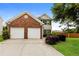 Well-maintained two-story house featuring a two-car garage, manicured bushes, and a green lawn at 11576 Kades Trl, Hampton, GA 30228