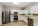 Bright kitchen with stainless steel appliances, white cabinets, and a window over the sink at 11576 Kades Trl, Hampton, GA 30228