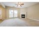 Large living room with fireplace, neutral carpet and paint, and bright windows at 11576 Kades Trl, Hampton, GA 30228