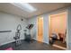 Basement workout area featuring exercise equipment, gym flooring, and adjacent storage space and bathroom at 2071 Arrowhead Trl, Marietta, GA 30062