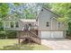 Two-story home featuring wood and siding exterior, multi-car garage, and an elevated wooden front porch and entry at 2071 Arrowhead Trl, Marietta, GA 30062