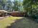 Backyard featuring a brick home, wooden deck with furniture, and lush greenery, perfect for outdoor enjoyment at 224 Sourwood Dr, Marietta, GA 30062
