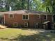 Backyard view showcasing the brick exterior, windows, and an adjacent wooden structure offering storage or shelter at 224 Sourwood Dr, Marietta, GA 30062