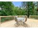Wooden deck with table and chairs surrounded by lush trees in backyard at 4710 Misty Lake Ne Ct, Kennesaw, GA 30144
