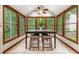 Sunlit dining area surrounded by large windows with wooded backyard views at 4710 Misty Lake Ne Ct, Kennesaw, GA 30144