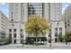 Elegant exterior view of a luxury building with well-manicured landscaping, a large tree, and street access at 75 14Th St Ne # 4140, Atlanta, GA 30309