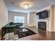 Elegant living room features hardwood floors, a modern fireplace, and a stylish velvet sofa at 1005 Belfry Ter, Fairburn, GA 30213