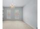 Bedroom with light-colored walls, carpet, chandelier, and two windows with shutter blinds at 1211 Riverscall Ln, Atlanta, GA 30339