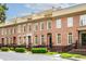 Beautiful brick townhomes featuring white trim, black iron railings and lush green landscaping at 1211 Riverscall Ln, Atlanta, GA 30339