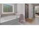 Bright bathroom featuring a tub, shower and tile floors at 4815 Edgemoore Trce, Cumming, GA 30040