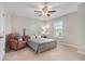 Bright bedroom featuring a neutral color scheme, a ceiling fan, and a red accent chair at 4815 Edgemoore Trce, Cumming, GA 30040