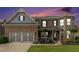 Charming brick home featuring a two-car garage, manicured lawn, and stylish architectural details at sunset at 4815 Edgemoore Trce, Cumming, GA 30040
