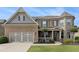 Inviting two-story home with manicured lawn, stone accents, and attached two car garage at 4815 Edgemoore Trce, Cumming, GA 30040
