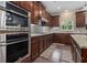 Modern kitchen with stainless steel appliances, dark wood cabinetry, and a stylish backsplash at 4815 Edgemoore Trce, Cumming, GA 30040