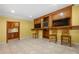 Finished basement featuring a kitchenette, built-in entertainment center, and tile flooring at 5312 Tormeal Trce, Suwanee, GA 30024