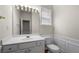 Elegant half bathroom with a large mirror, wood-look floors, and decorative molding at 5312 Tormeal Trce, Suwanee, GA 30024