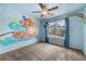 Colorful bedroom with unique artwork, a ceiling fan, a window, and neutral carpet at 5312 Tormeal Trce, Suwanee, GA 30024