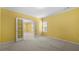 A bright bedroom with neutral carpet and yellow walls has an adjacent room through glass paneled doors at 5312 Tormeal Trce, Suwanee, GA 30024