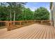 Wooden deck with railings has stair access to backyard and has a view of mature green trees at 5312 Tormeal Trce, Suwanee, GA 30024